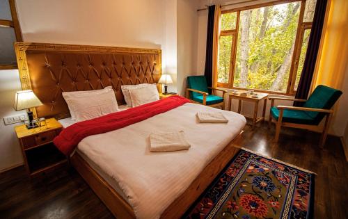 列城Tushita Ladakh的一间卧室配有一张大床、两把椅子和一扇窗户