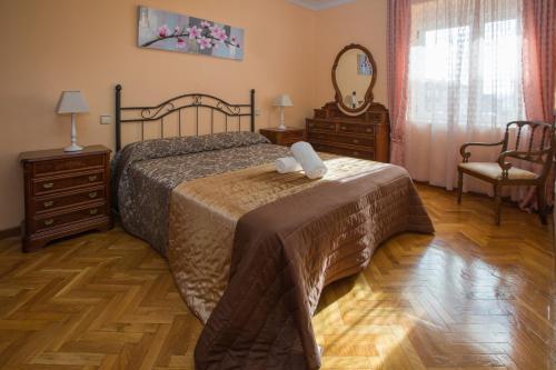 阿维拉Apartamentos Turisticos Avila Villa Carmen II的一间卧室配有床、两个梳妆台和镜子