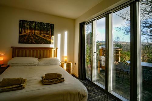 PontardaweBeili Glas Cottage的一间卧室设有一张床和一个大型玻璃窗