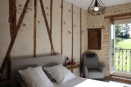 莫南Maison d'hôtes Marimpoey的卧室配有床、椅子和窗户。