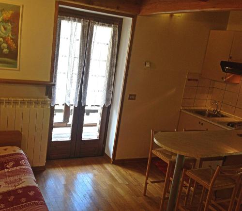 阿兰尼亚·瓦尔塞西娅Residence Casa dei Fiori的厨房配有桌子和带窗户的门