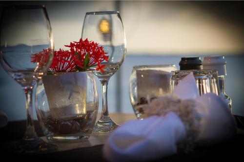 克拉伦代克Den Laman - Balloonfish的一张桌子,上面有眼镜和花瓶,上面有红花