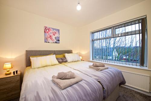 曼彻斯特Beautiful Cozy Home With Free Parking的一间卧室配有一张大床和两条毛巾