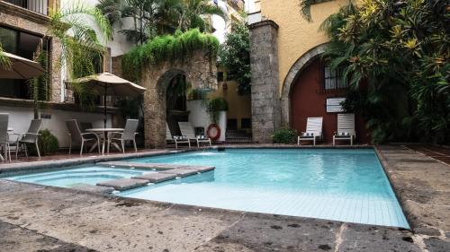 瓜达拉哈拉门多萨酒店 的大楼前的游泳池