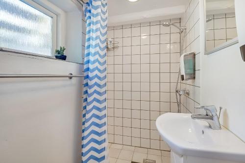 埃斯比约Sweethome Guesthouse的浴室设有蓝色和白色的浴帘和水槽