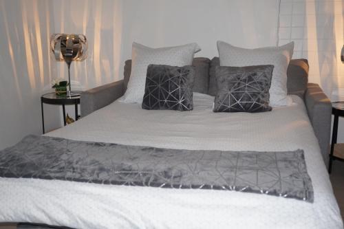 滨海贝尔克Appartement de standing的一张铺有灰色和白色床单的床和枕头