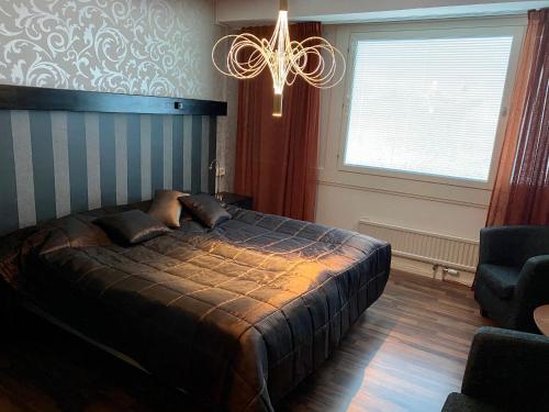 OckelboBaren i Ockelbo的一间卧室配有一张大床和一个吊灯。