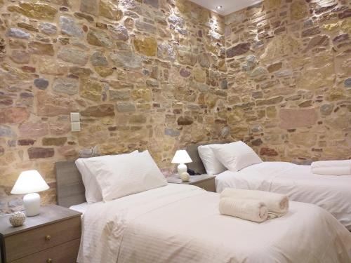 希俄斯CityZen Rooms Chios的石墙客房的两张床