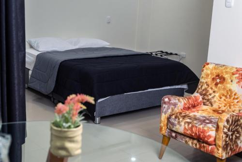 通贝斯MiniApartamentos GRAN IMPERIAL PREMIUM的一间卧室配有一张床和一把椅子