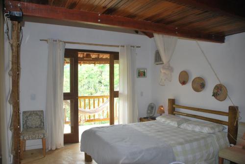 韦尔卡鲍Casa do Capão的一间卧室设有一张床和一个滑动玻璃门