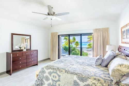 西湾Beach Living at Villas Pappagallo (BLPD)的一间卧室配有一张床、一个梳妆台和一扇窗户。