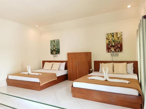 吉利美诺两兄弟旅馆的一间卧室配有两张床,墙上有两幅画作