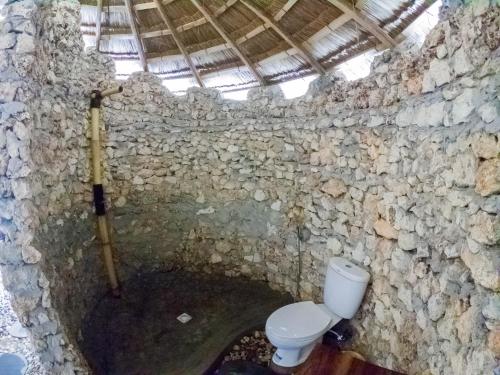 万加普Costa Beach Resort & Club的石质浴室,洞穴内有厕所