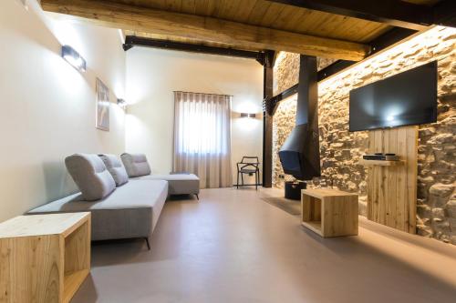 Castel del GiudiceBorgotufi Albergo Diffuso的带沙发和电视的客厅