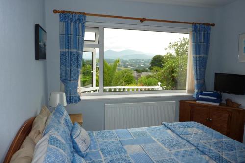 梅奈布里奇Eildon的一间卧室设有一张床和一个大窗户