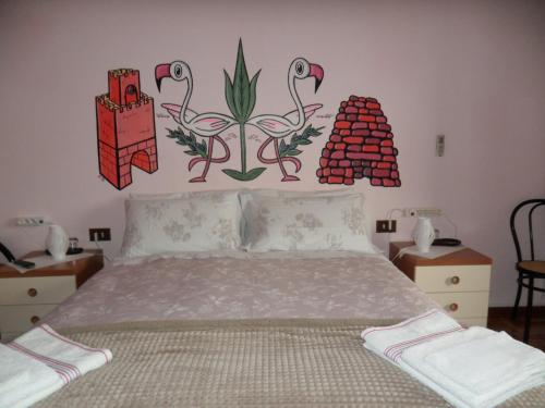 奥里斯塔诺B&B Il Mirto的卧室配有一张挂着鲜花的床