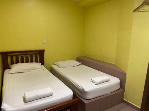 RembauHotel Rembau的小型客房 - 带两张床和绿色墙壁