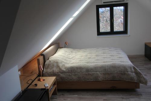 包道乔尼托毛伊Éliás Borbirtok的卧室配有一张床,墙上设有窗户