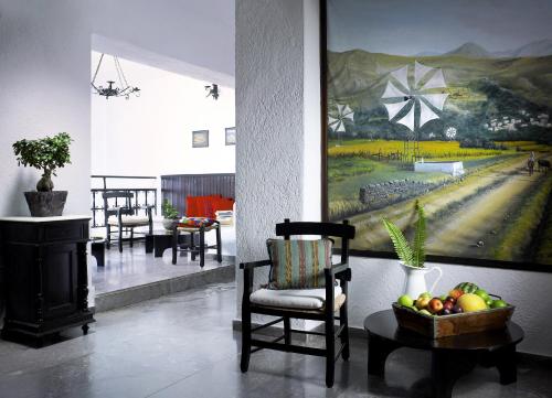 阿基欧斯尼古拉斯维多利亚酒店的一间设有椅子的房间和墙上的绘画