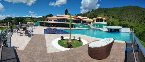 阿瓜斯迪林多亚Fazenda Morro Pelado的一个带游泳池和房子的度假胜地