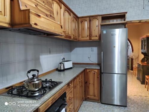 比尔泽布贾Arzella Holiday Home的厨房配有木制橱柜和不锈钢冰箱。