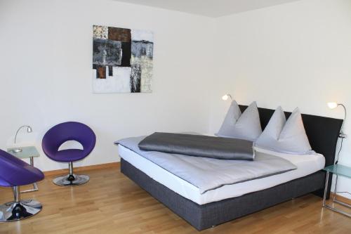 索内纳尔佩·纳斯费尔德Ferienapartment Nassfeld的一间卧室配有一张床和一张紫色椅子