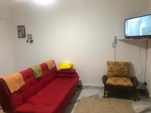 伯迪亚哥Cantinho da Lu em apt inteiro 800 mt da praia的客厅配有红色的沙发和椅子