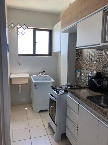 马塞约Apartamento 02 quartos completo, BEIRA-MAR com piscina的厨房配有水槽和炉灶 顶部烤箱