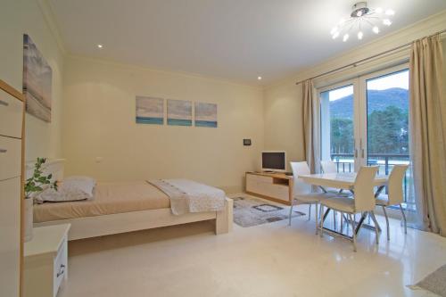 蒂瓦特Porto Montenegro Zeta 102 - Cozy Studio的一间卧室配有一张床、一张桌子和一张桌子