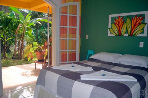 乌巴图巴Pousada Capim Melado的一间卧室设有一张床和绿色的墙壁