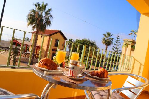 贝纳哈拉菲HOSTAL LA ESTACION的一张桌子,早餐包括羊角面包和橙汁