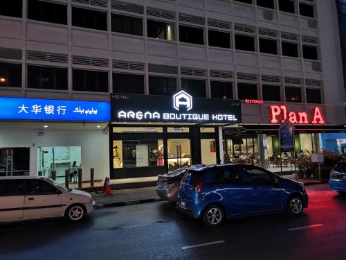 瓜拉丁加奴ARENA Boutique Hotel Kuala Terengganu的夜间停在大楼前的汽车