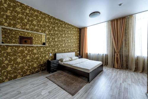 彼尔姆Hotel Azia的一间卧室配有床和一堵带金色壁纸的墙