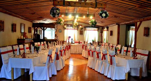 苏兹达尔苏兹达尔生态酒店的宴会厅配有白色桌子和红色椅子