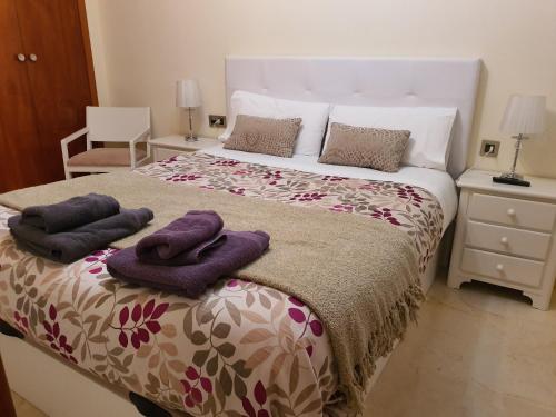 哈恩Jaen Home的一间卧室配有一张带紫色毛巾的床