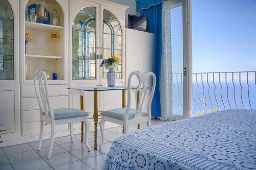 阿纳卡普里B&B Il Bacio di Capri的一间卧室配有桌子、两把椅子和一张床