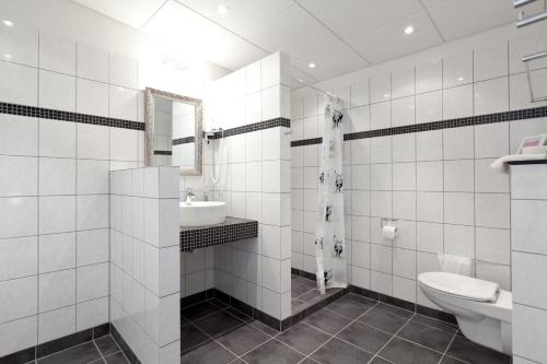JyderupBromølle Kro的白色瓷砖浴室设有卫生间和水槽