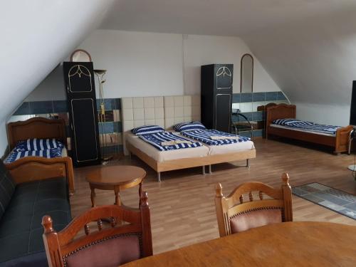 Ivanka pri DunajiMotel Kotva的一间设有两张床和一张桌子及椅子的房间