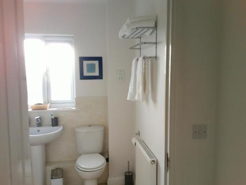 伦敦Two bedroom London Luxury Apartment的一间带卫生间、水槽和窗户的浴室