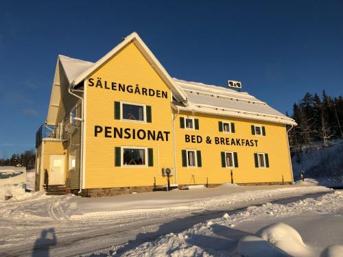 VörderåsSälengården的雪上标有黄色房子