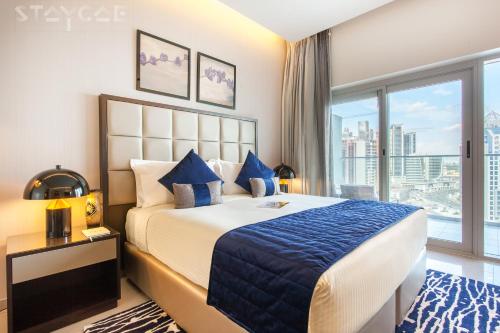迪拜Staycae Holiday Homes - Majestine的一间卧室设有一张大床和一个大窗户