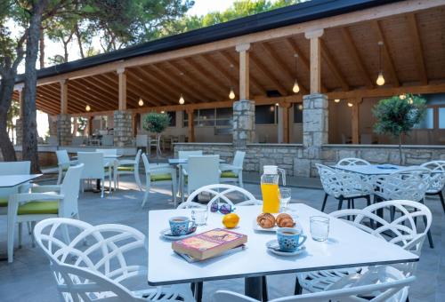法扎纳Mobile Homes Camp Pineta - Adriatic Kampovi的一张带一盘食物和橙汁的白色桌子