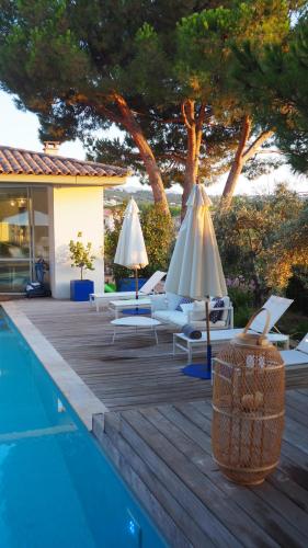 波尔蒂乔Les Suites d'Agosta的房屋旁的游泳池配有椅子和遮阳伞