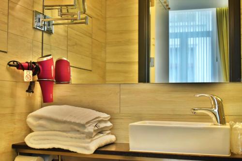 布鲁塞尔布鲁塞尔大广场市集酒店的浴室配有盥洗盆、镜子和毛巾
