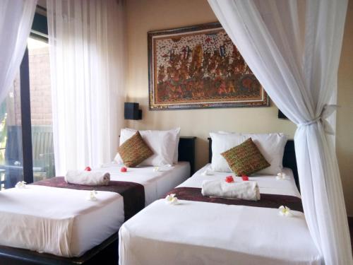 佩母德兰萨里别墅酒店的配有窗帘的酒店客房内的两张床