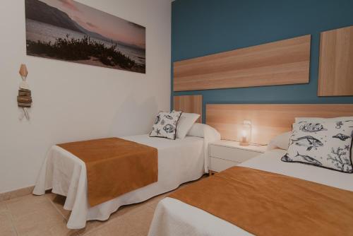 塞博河畔卡莱塔La Pardela Experience Apartamentos的一间酒店客房,房间内设有两张床