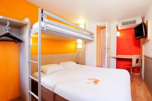 蒙德维尔东卡昂 - 蒙德维尔普瑞米尔经典酒店的一间卧室配有一张床和一张双层床。