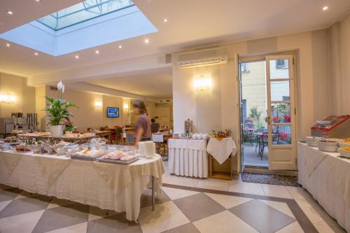 都灵罗马和凯沃尔岩酒店的一间餐厅,配有两张桌子,上面有食物