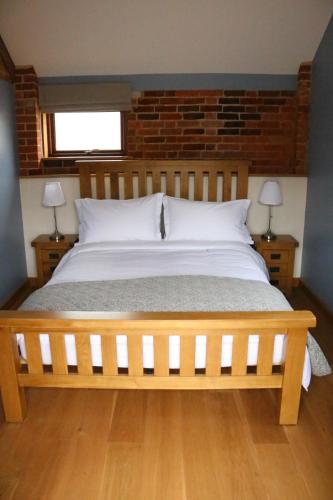 灵伍德Blashford Manor Farmhouse - The Shetland Cottage的一间卧室配有一张带两盏灯的大木床。
