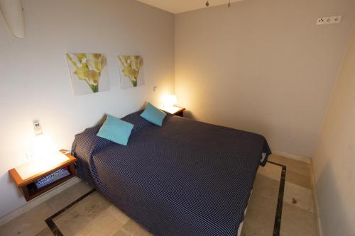 克拉伦代克Seaside Apartment Pelican的一间卧室配有一张带蓝色枕头的大床